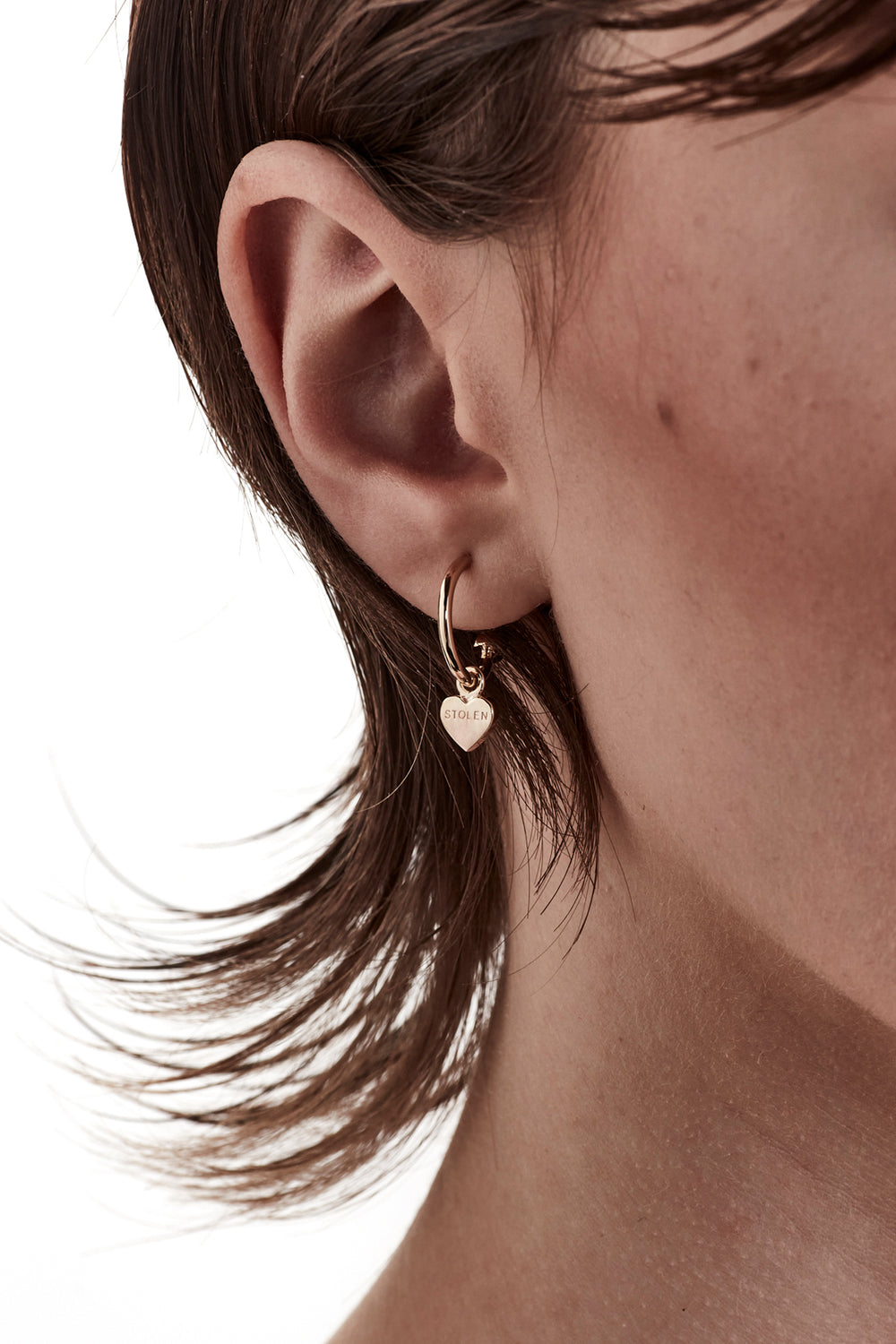 STOLEN GIRLFRIENDS CLUB STOLEN HEART ANCHOR SLEEPER  The Stolen Girlfriends Club Stolen Heart Anchor Sleepers are gorgeous half hoop stud-style, each suspending a mini heart, which features signature 'Stolen' engraving across the front.  These sleepers are great for every day wear. Crafted using 18k gold plating, pair these with the matching studs, other sleepers or wear alone.