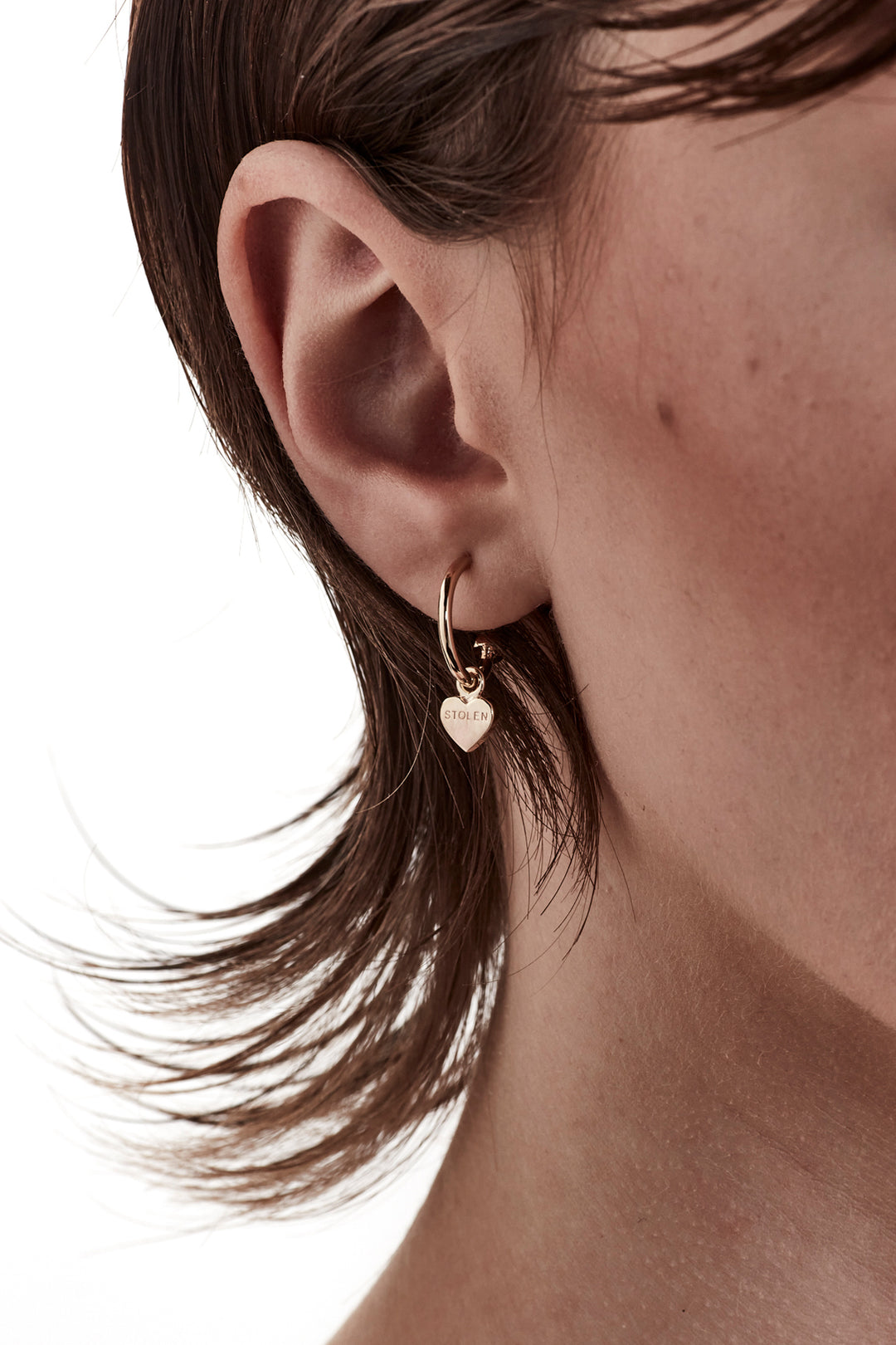 STOLEN GIRLFRIENDS CLUB STOLEN HEART ANCHOR SLEEPER  The Stolen Girlfriends Club Stolen Heart Anchor Sleepers are gorgeous half hoop stud-style, each suspending a mini heart, which features signature 'Stolen' engraving across the front.  These sleepers are great for every day wear. Crafted using 18k gold plating, pair these with the matching studs, other sleepers or wear alone.