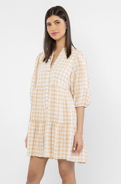 The Billie The Label Truthful Mini Dress is available in camel check. It features a v neck line, 3 tiers, a buttoned down front and is lined. Team back with sandals or trainers for summer for a cute fit.   Lined  Button closure  V neckline 100% Polyester 