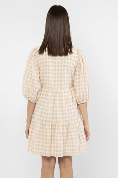The Billie The Label Truthful Mini Dress is available in camel check. It features a v neck line, 3 tiers, a buttoned down front and is lined. Team back with sandals or trainers for summer for a cute fit.   Lined  Button closure  V neckline 100% Polyester 