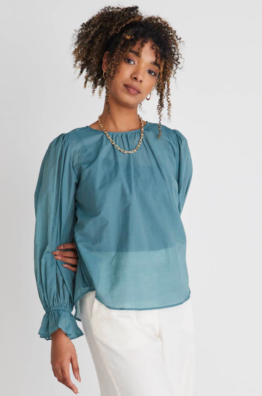 Introducing the Candid Top from By Rosa, a versatile addition to your wardrobe. This stunning lightweight blouse is designed to effortlessly transition you from the office to after-work drinks, making it a must-have for the modern woman on the go.      Long sleeve     Frill elastic sleeves     Ruched shoulders     Rounded neckline     70% cotton 30% tencel