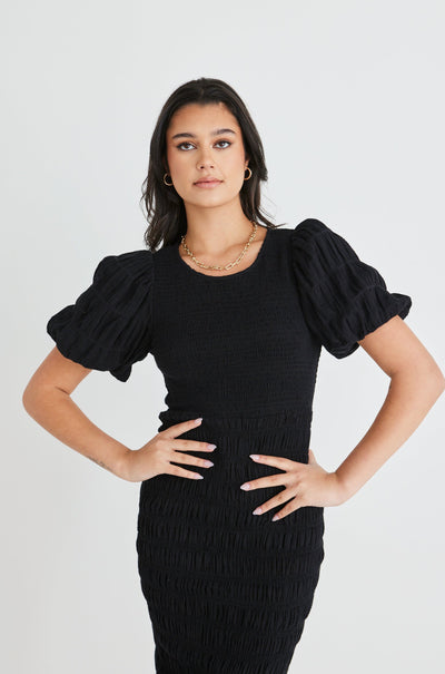 The Jade Black Dress by Ivy + Jack is here to be your forever favourite! Featuring an elegant and flattering ruched body, and gorgeous puff sleeves that create a stunning silhouette, this dress won't let you down. Pair with some little black heels for an evening look or white sneakers and a crossbody bag for daytime styling.       Ruched Bodycon     Puff sleeves      Round neckline     Stretch Material      Midi length 