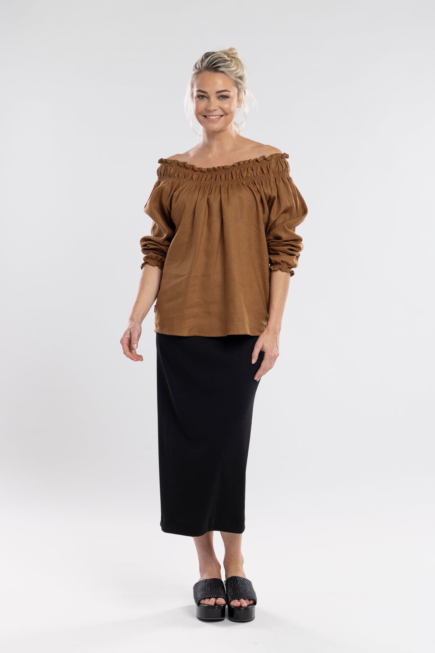 An off the shoulder design with the option to wear up, features a shirred neckline which creates a relaxed drape through the body.  A feminine and fun piece!       Linen/cotton     Shirred neckline     Cuff sleeves 