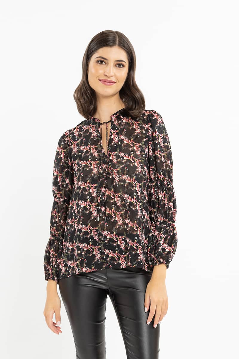 Seeking Lola Jubilant Top - Pink Fancy  The Seeking Lola Jubilant Top is available in this fun pink floral fancy print. It features a high neck with tie, although can be worn undone with a n neck for multiple ways to wear. This sheer top teams perfectly back with any bottoms.       Neck tie detail     Elasticated cuffs     Button detail below v neckline     Sheer fabric     100% Polyester