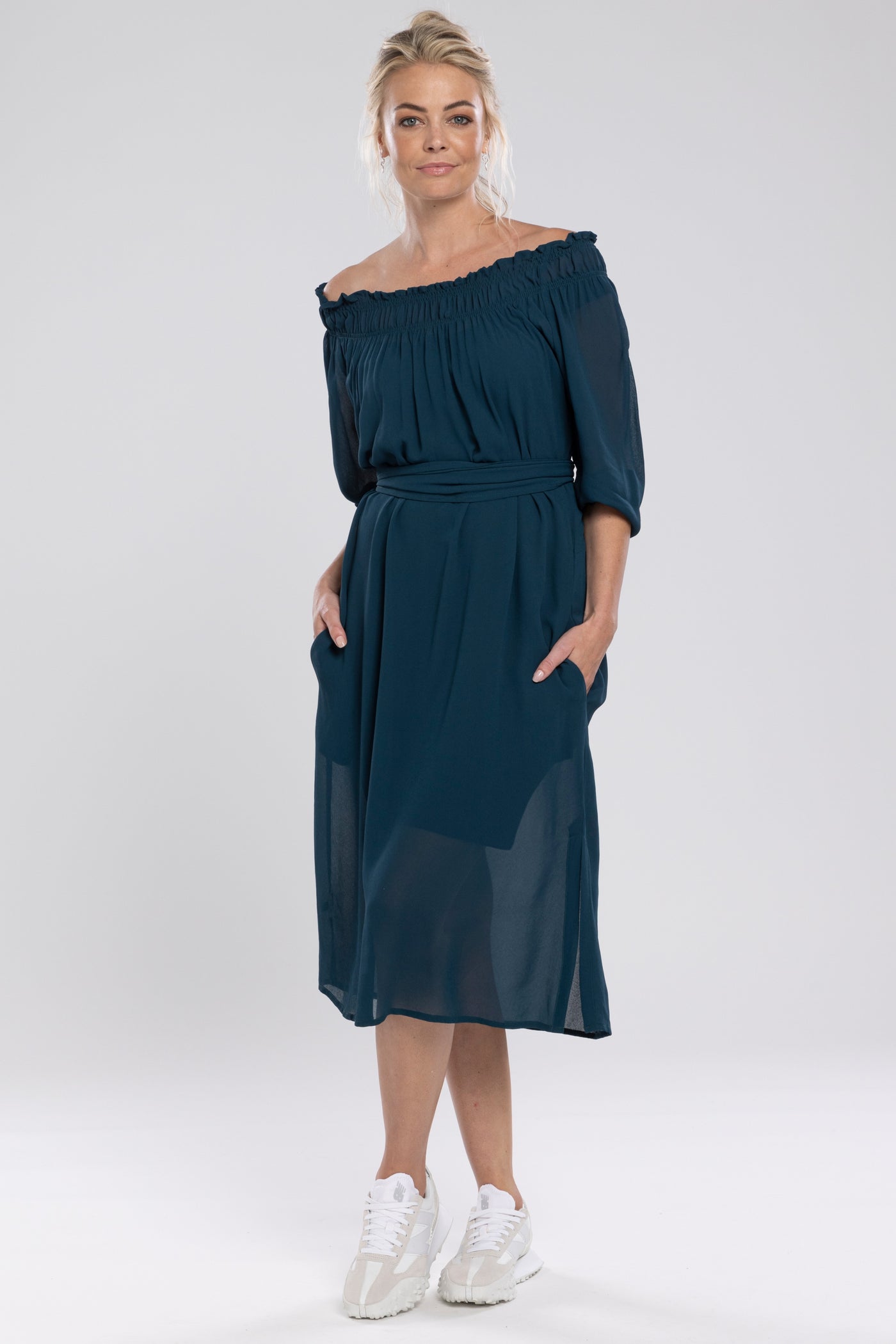 The Merchant Dress is a new style. Great dress to dress up or down. An off the shoulder design with the option to wear up. It features a shirred neckline which creates a relaxed drape through the body. Side Seam Pockets & a waist belt can be worn ties or left untied.      Length finishes below the knee.     A feminine and fun piece!     Viscose