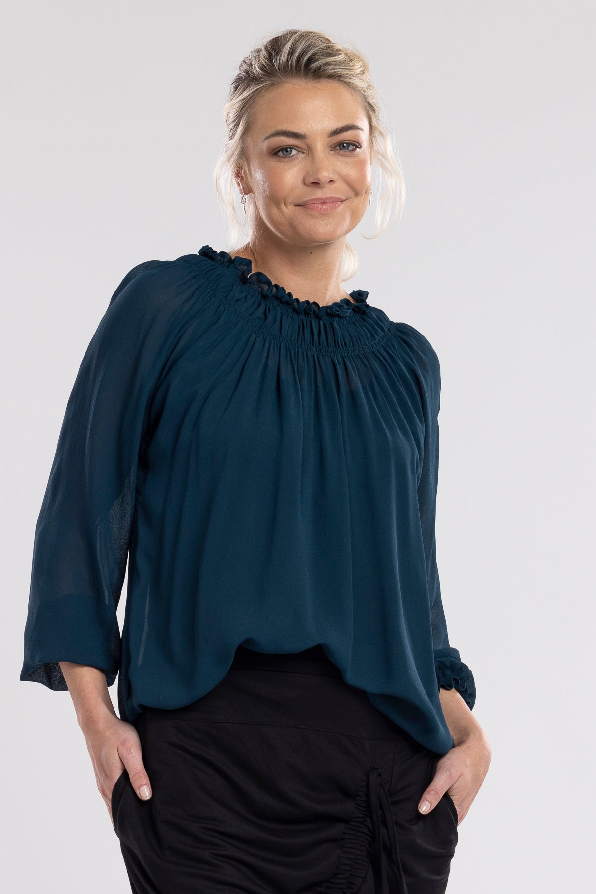 An off the shoulder design with the option to wear up, features a shirred neckline which creates a relaxed drape through the body.  A feminine and fun piece!       Viscose     Shirred neckline     Cuff sleeves 