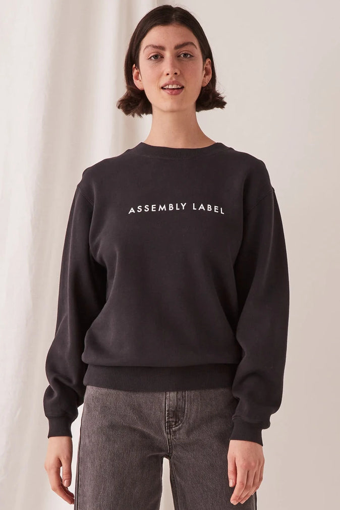 ASSEMBLY LABEL LOGO FLEECE  The Assembly Label Logo Fleece is a cult favourite slogan crew perfect for the cooler months. The Logo Fleece features a relaxed fit, with a ribbed crew neckline, and signature 'Assembly Label' printing across the front chest, finishing with ribbed sleeve cuffs. 