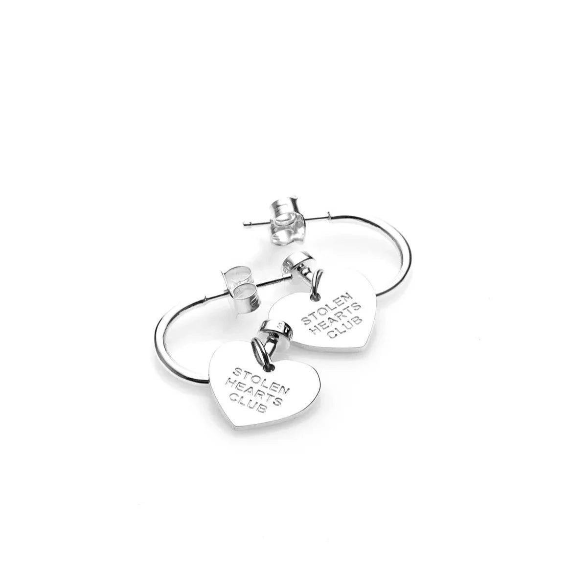 STOLEN GIRLFRIENDS CLUB STOLEN HEART CLUB EARRINGS  The Stolen Girlfriends Club Stolen Heart Sleepers are gorgeous half hoop stud-style, each suspending a heart charm, which features signature 'STOLEN HEARTS FOREVER' engraving across the front.