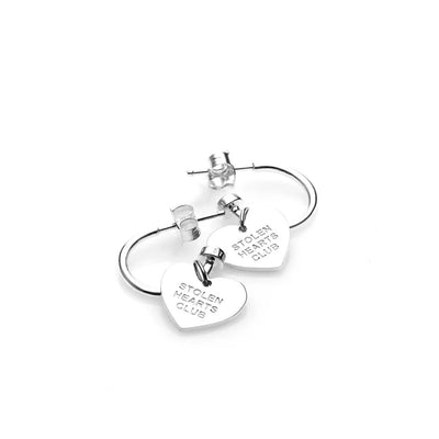 STOLEN GIRLFRIENDS CLUB STOLEN HEART CLUB EARRINGS  The Stolen Girlfriends Club Stolen Heart Sleepers are gorgeous half hoop stud-style, each suspending a heart charm, which features signature 'STOLEN HEARTS FOREVER' engraving across the front.