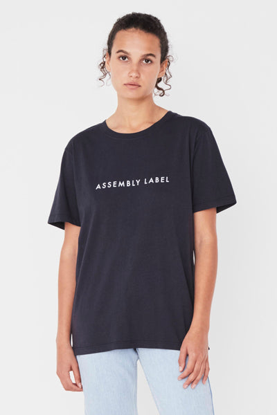 ASSEMBLY LABEL LOGO COTTON CREW TEE  The Assembly Label Logo Cotton Crew Tee is a classic slogan tee perfect for every day wear. The Logo Cotton Crew is the t-shirt version of the cult favourite Assembly Label Logo Fleece  The Assembly Label Logo Cotton Crew Tee features a relaxed silhouette and crew neckline, finishing with signature 'Assembly Label' screen print across the chest. 