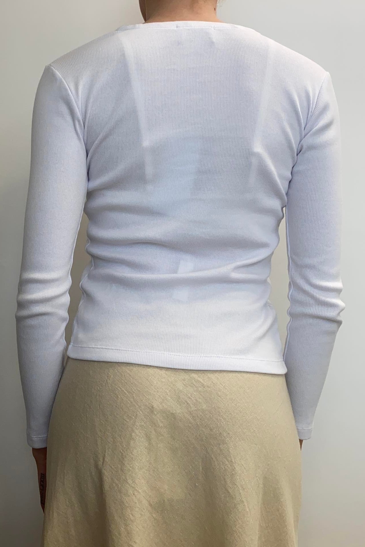 BLAK STAY WITH ME CARDI - WHITE  The Blak Stay With Me Cardi is a simple, form-fitting long sleeve now available in; White.  The Stay With Me Cardi features a flattering v-neckline, moving to a button-up front, finished with the split below the buttons.