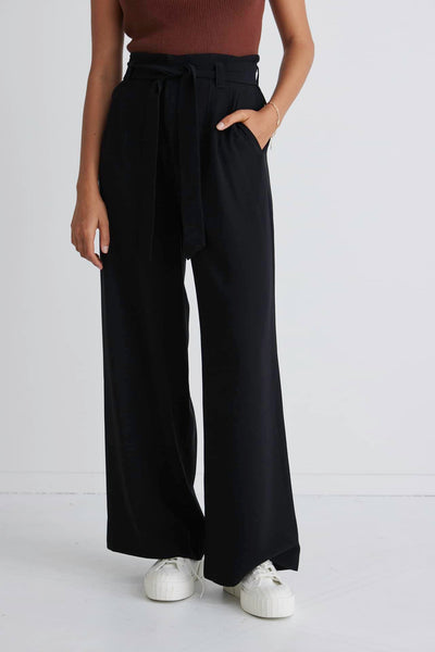 Stories Be Told Sydney Crepe Tie Belt Pant - Black  The Stories Be Told Sydney Pant is available in classic black. It features a paper bag waist, a belt to tie, pockets and is a wide leg style This pant is a fantastic wardrobe staple to take you from one season to the next.  Team back with your favourite tops or knits and layer with jackets or coats in the cooler months. 