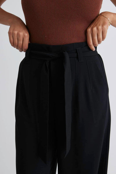 Stories Be Told Sydney Crepe Tie Belt Pant - Black  The Stories Be Told Sydney Pant is available in classic black. It features a paper bag waist, a belt to tie, pockets and is a wide leg style This pant is a fantastic wardrobe staple to take you from one season to the next.  Team back with your favourite tops or knits and layer with jackets or coats in the cooler months. 